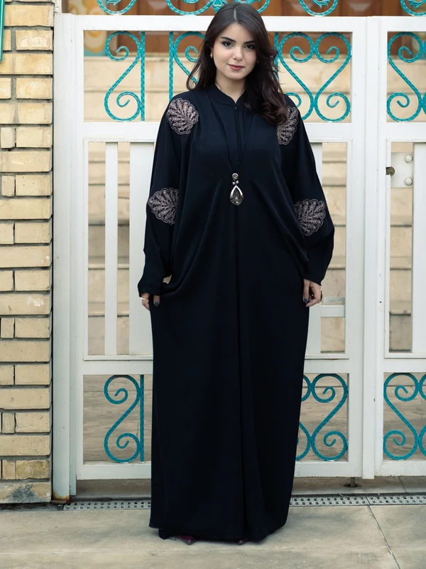 Illustrative: a black closed abaya with embroidered shoulders and full coverage. Licensed stock photograph, not our own product.