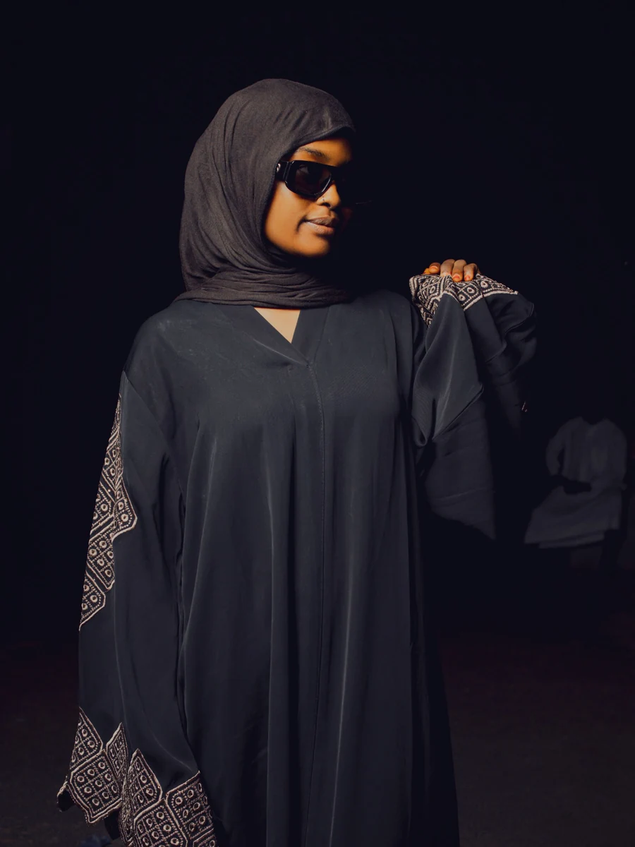 Illustrative: butterfly abaya wholesale — a black abaya with its wide wing sleeve held open. Licensed stock photograph, not our own product.
