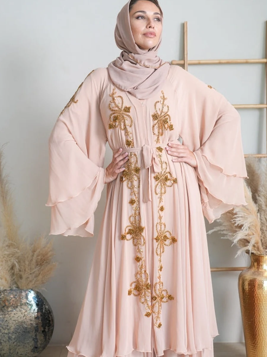 Illustrative: farasha abaya wholesale — a blush, wide-sleeve occasion abaya with gold embroidery. Licensed stock photograph, not our own product.