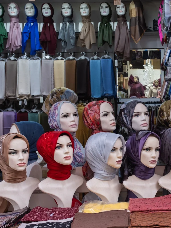 Illustrative: a shop wall of hijabs in many colours, shown on mannequins. Licensed stock photograph, not our own product.