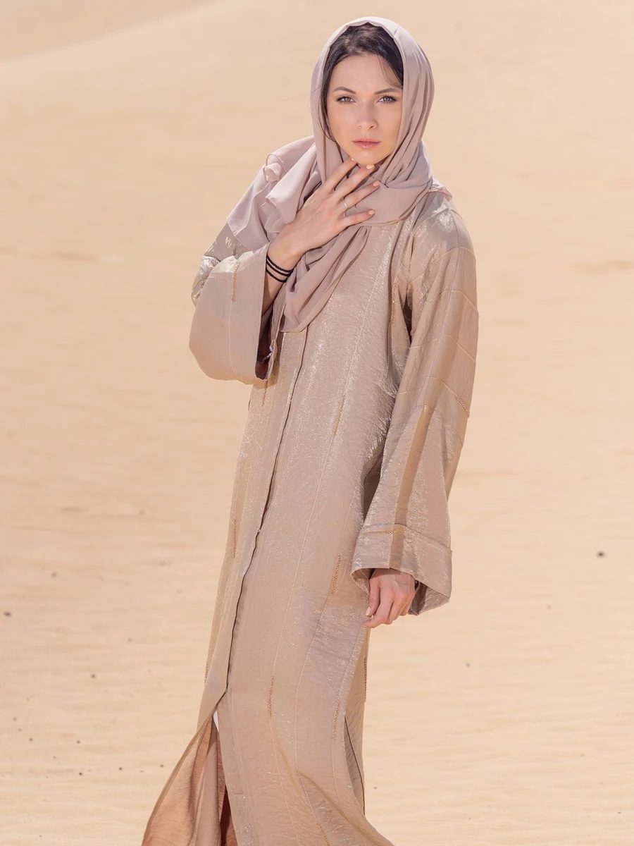 Illustrative: wholesale linen abaya — a loose, sand-coloured abaya worn in desert heat. Licensed stock photograph, not our own product.