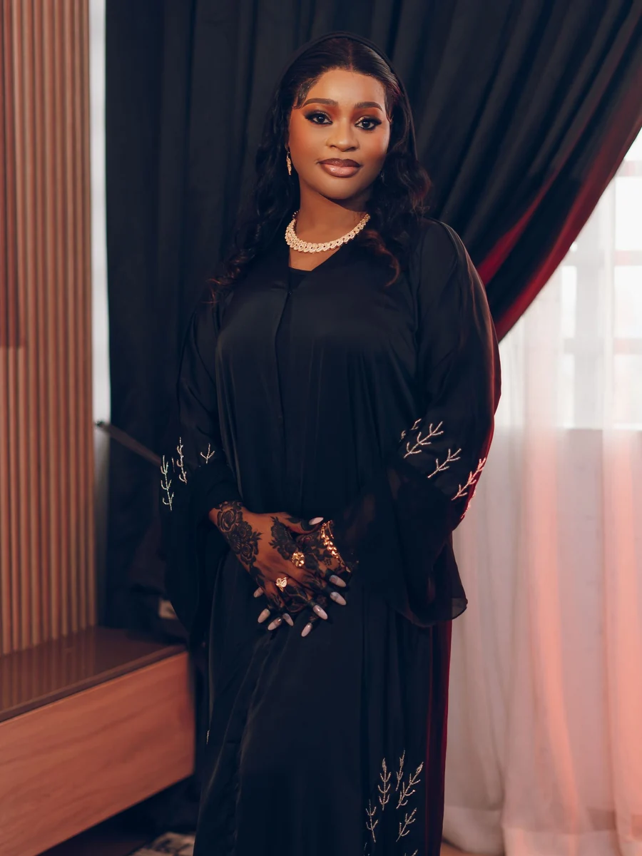 A black embellished abaya worn with pearls (illustrative stock photo)