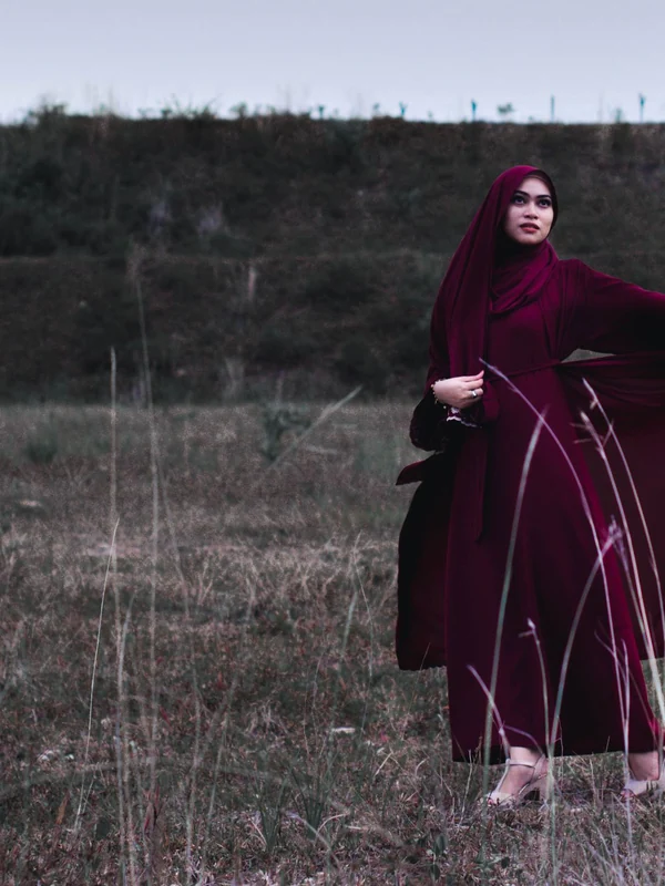 Illustrative: a maroon wide-sleeve abaya opened out like a wing. Licensed stock photograph, not our own product.