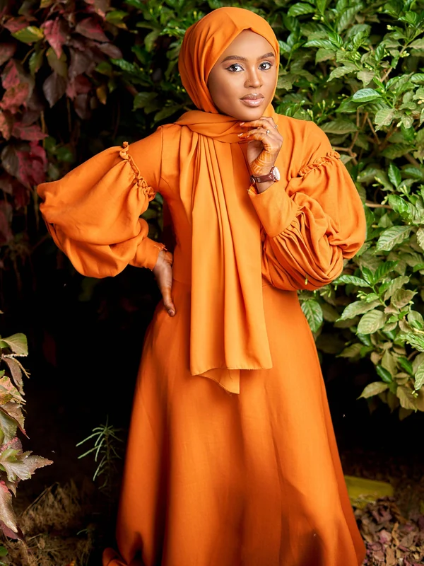 Illustrative: an orange abaya with full, dropped balloon sleeves. Licensed stock photograph, not our own product.