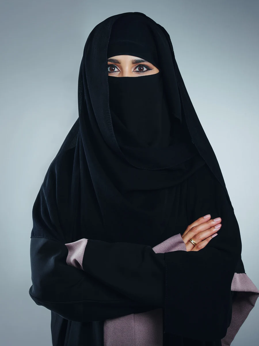 Illustrative: umrah abaya wholesale — a black abaya worn with a niqab, face covered. Licensed stock photograph, not our own product.