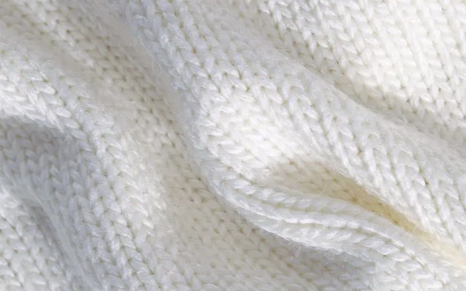 Close-up of soft white knit fabric in folds
