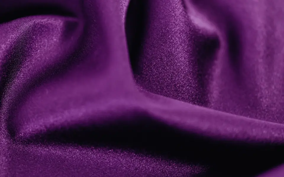 Close-up of purple fabric with a sheen over a fine grainy texture