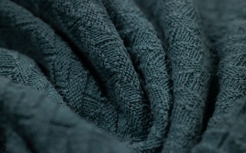 Close-up of teal knitted fabric in soft folds