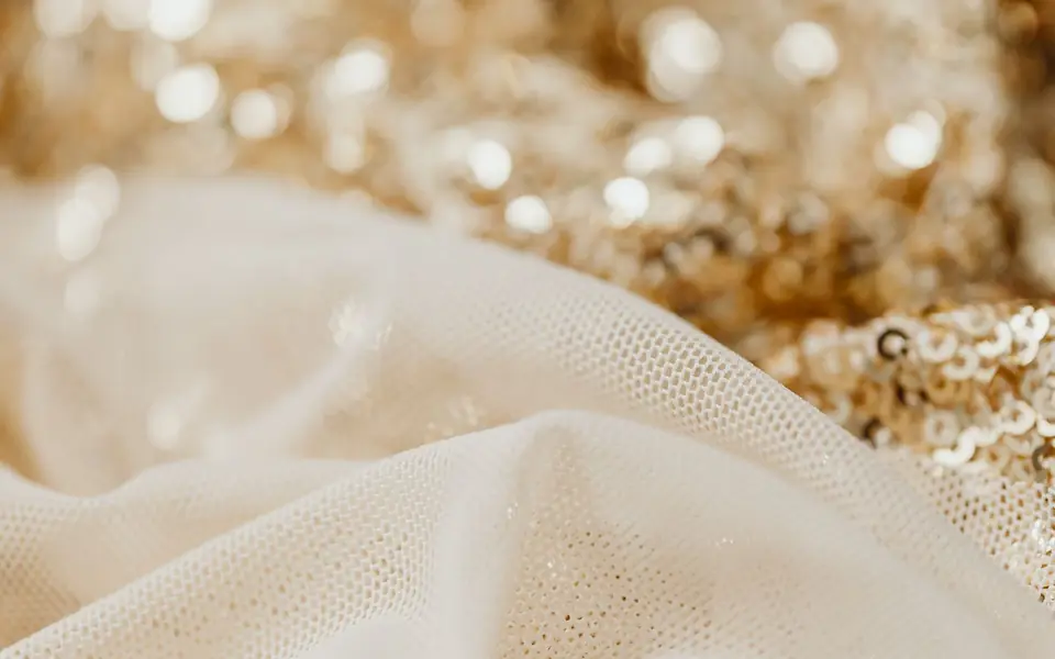 Sheer cream net laid over gold sequin fabric