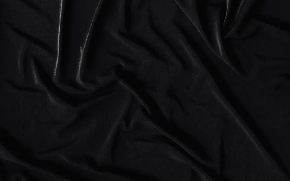 Close-up of black fabric with soft sheen gathered into folds