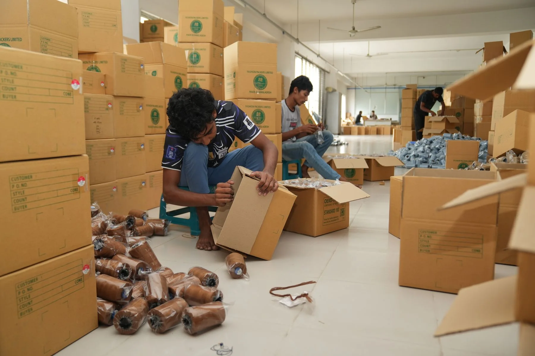 Illustrative: folded garments being packed. Licensed stock photograph, not taken during our production.