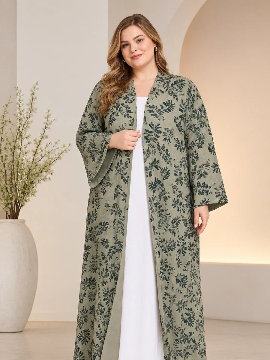 Wholesale plus size abaya: a sage leaf-print open abaya with wide sleeves on a plus-size model, over a white inner dress (illustrative image)