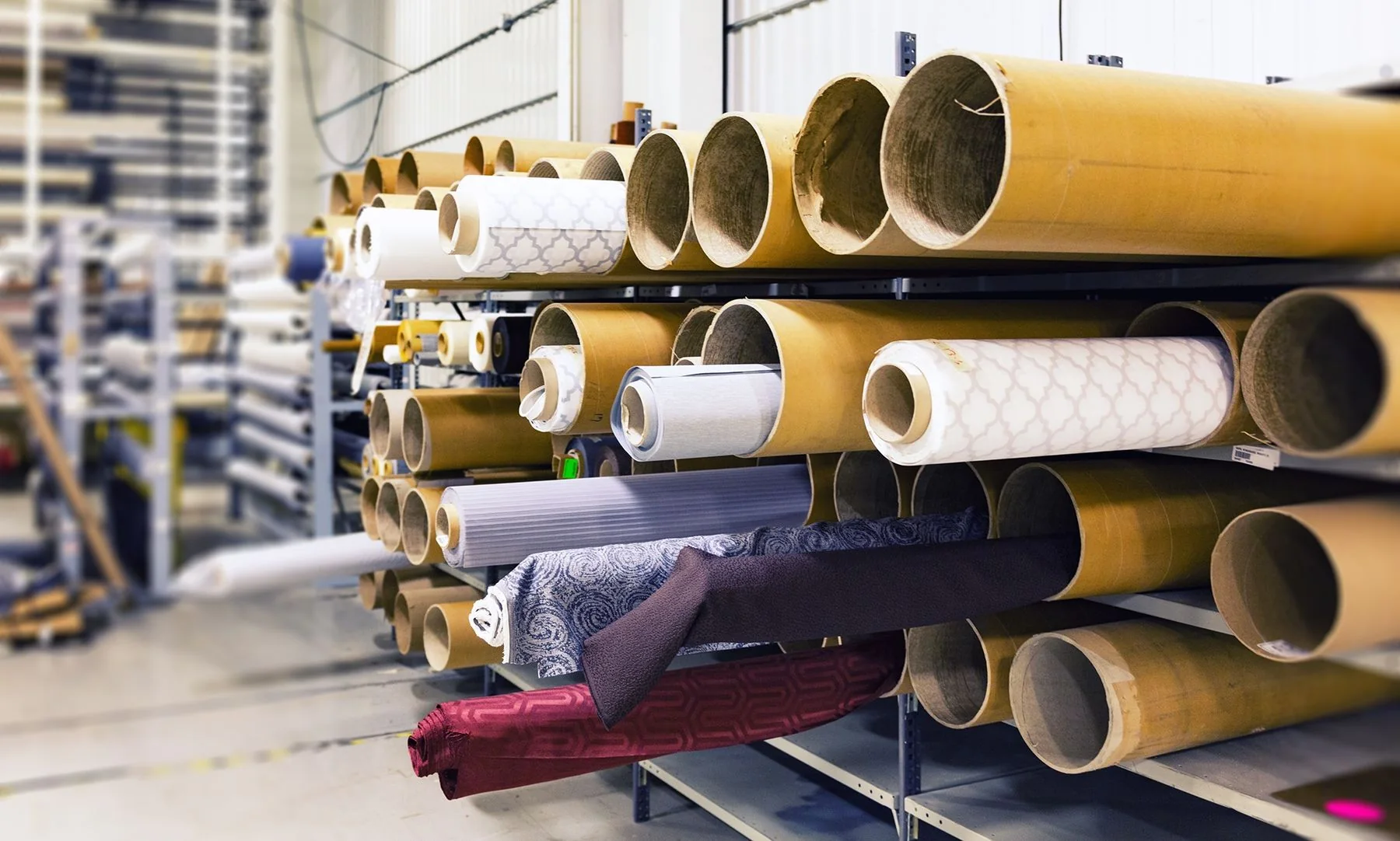 Rolls of textile stacked on warehouse racking (illustrative stock photo)
