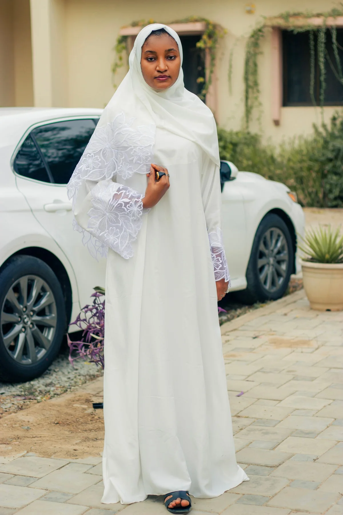 Illustrative: a white abaya worn. Licensed stock photograph, not our own product.