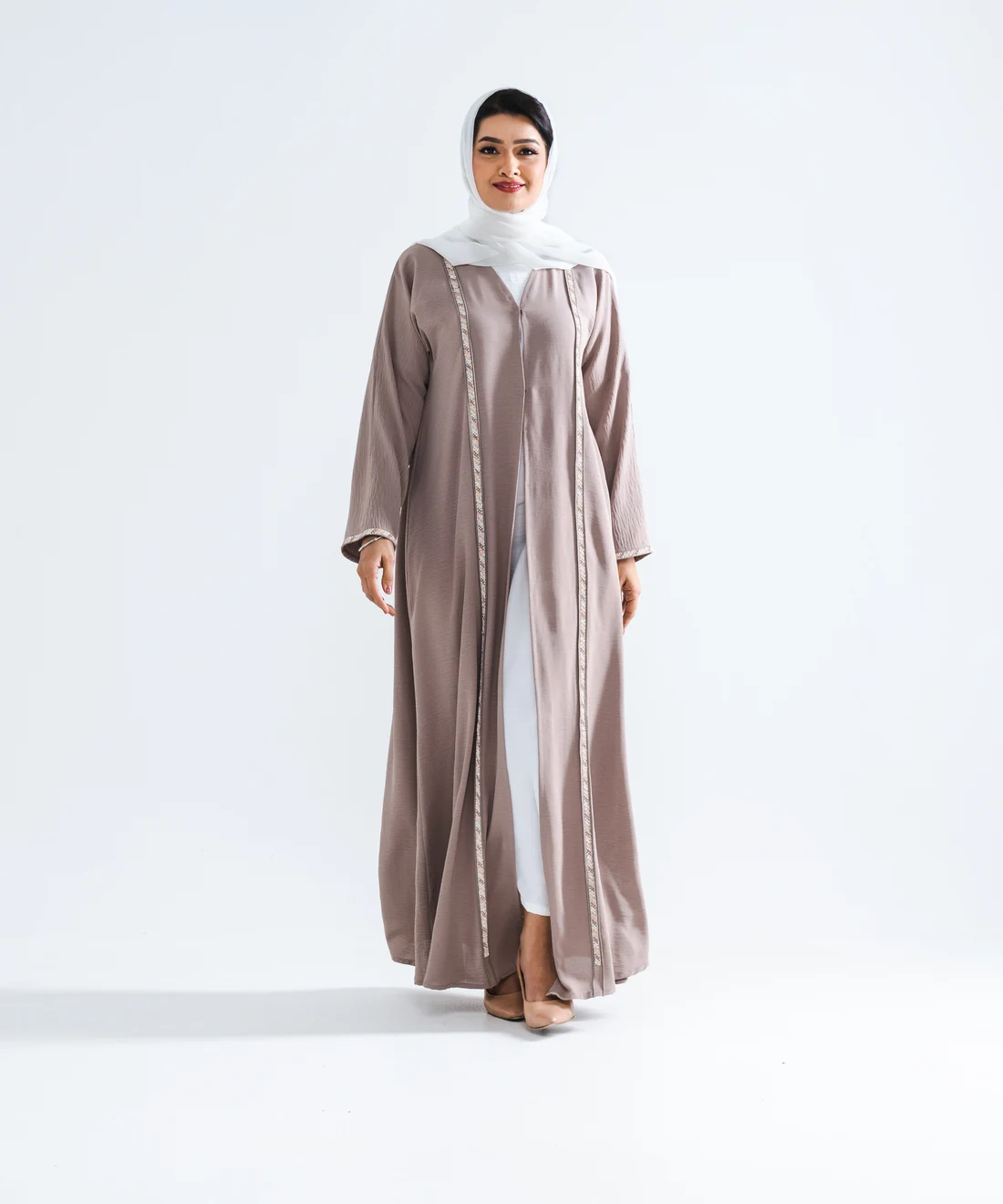 A taupe open abaya over a white inner dress, studio shot, from an abaya manufacturer in Dubai